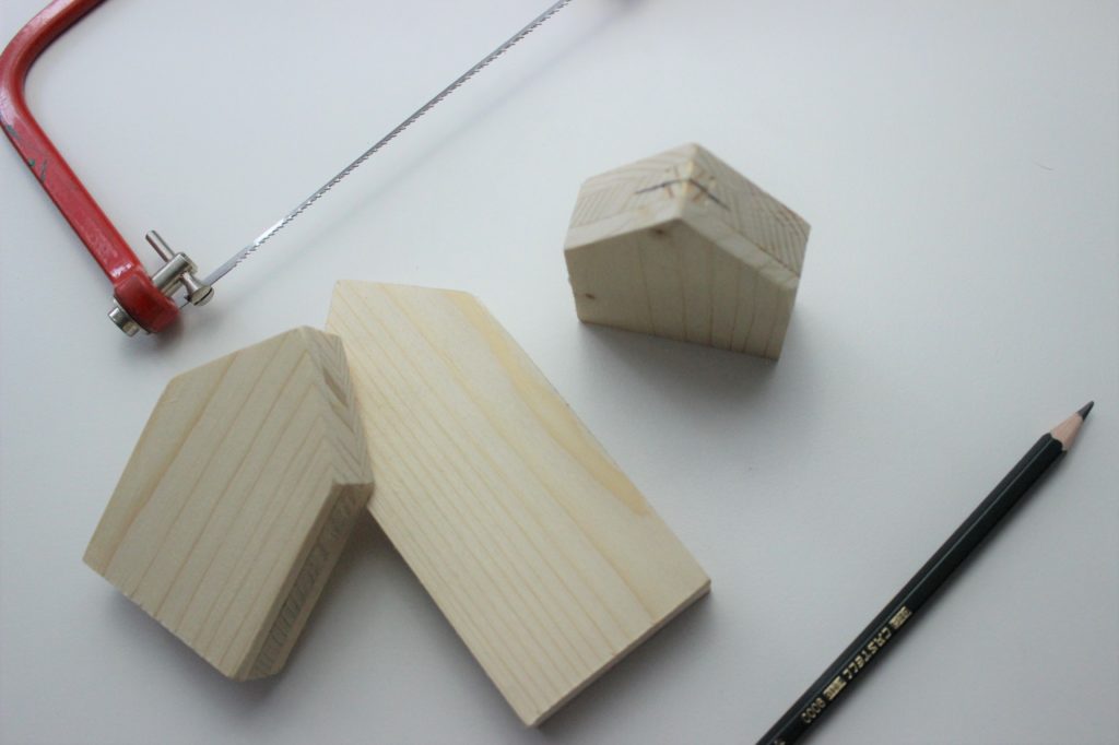 Häuser aus Holz, in welche ein Schlitz gesägt wird. Damit ein Fotohalter entsteht. 