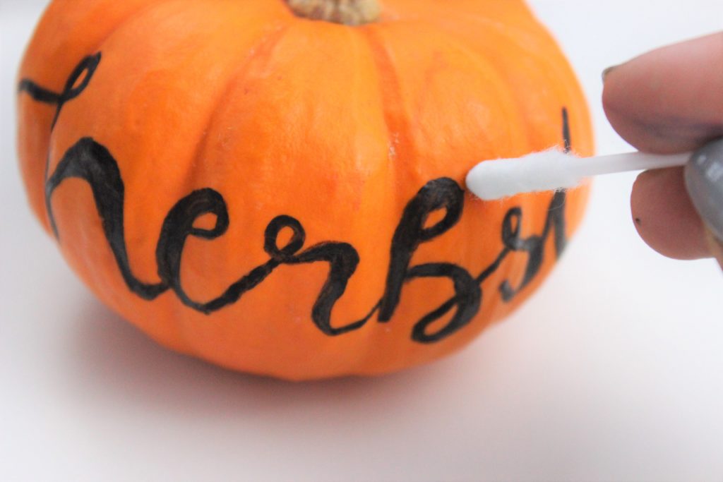 Fehler werden mit einem Wattestäbchen vom Kürbis entfernt.