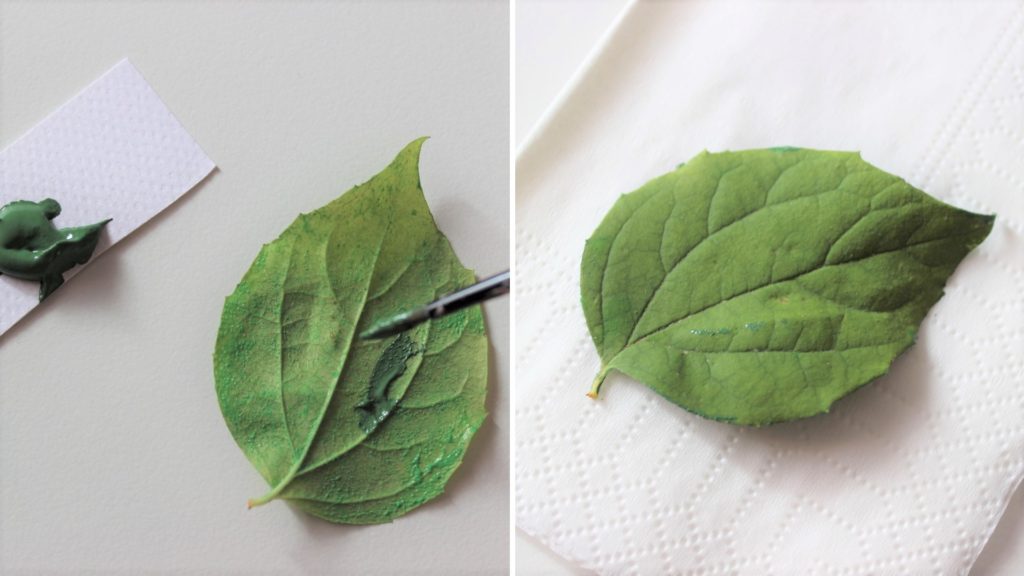 Ein Herbstblatt wird mit Farbe eingestrichen und auch eine weiße Serviette gedruckt.