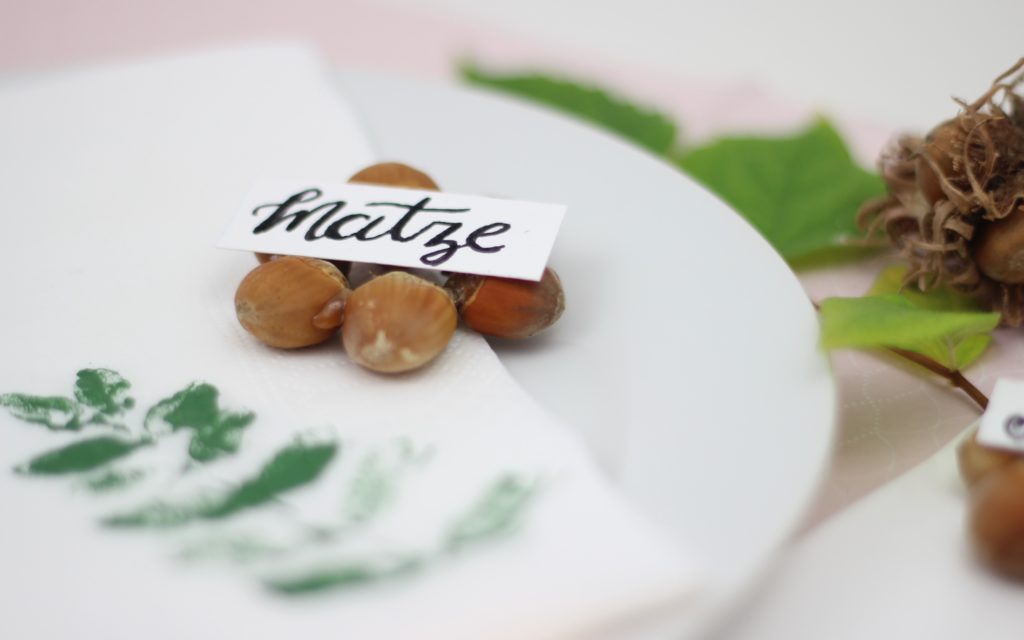 Haselnüsse aneinander geklebt als Platzschild.