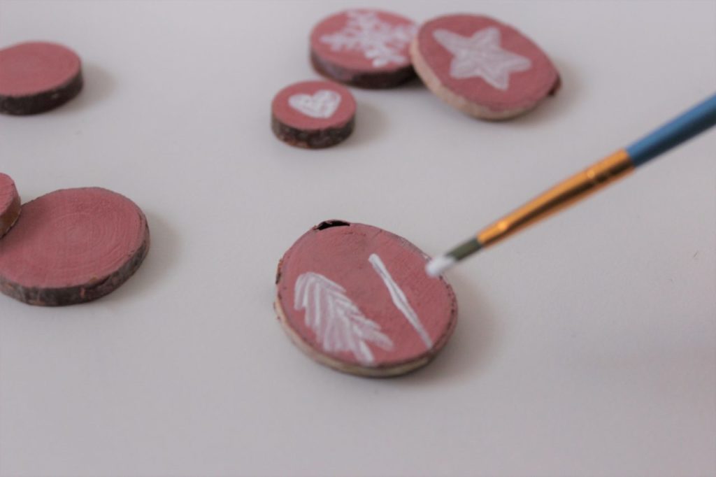 Winterliche Motive werden auf den selbst gemachten Adventskalender gemalt. 