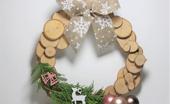 Selbst gemachter winterlicher Türkranz aus Holzscheiben.