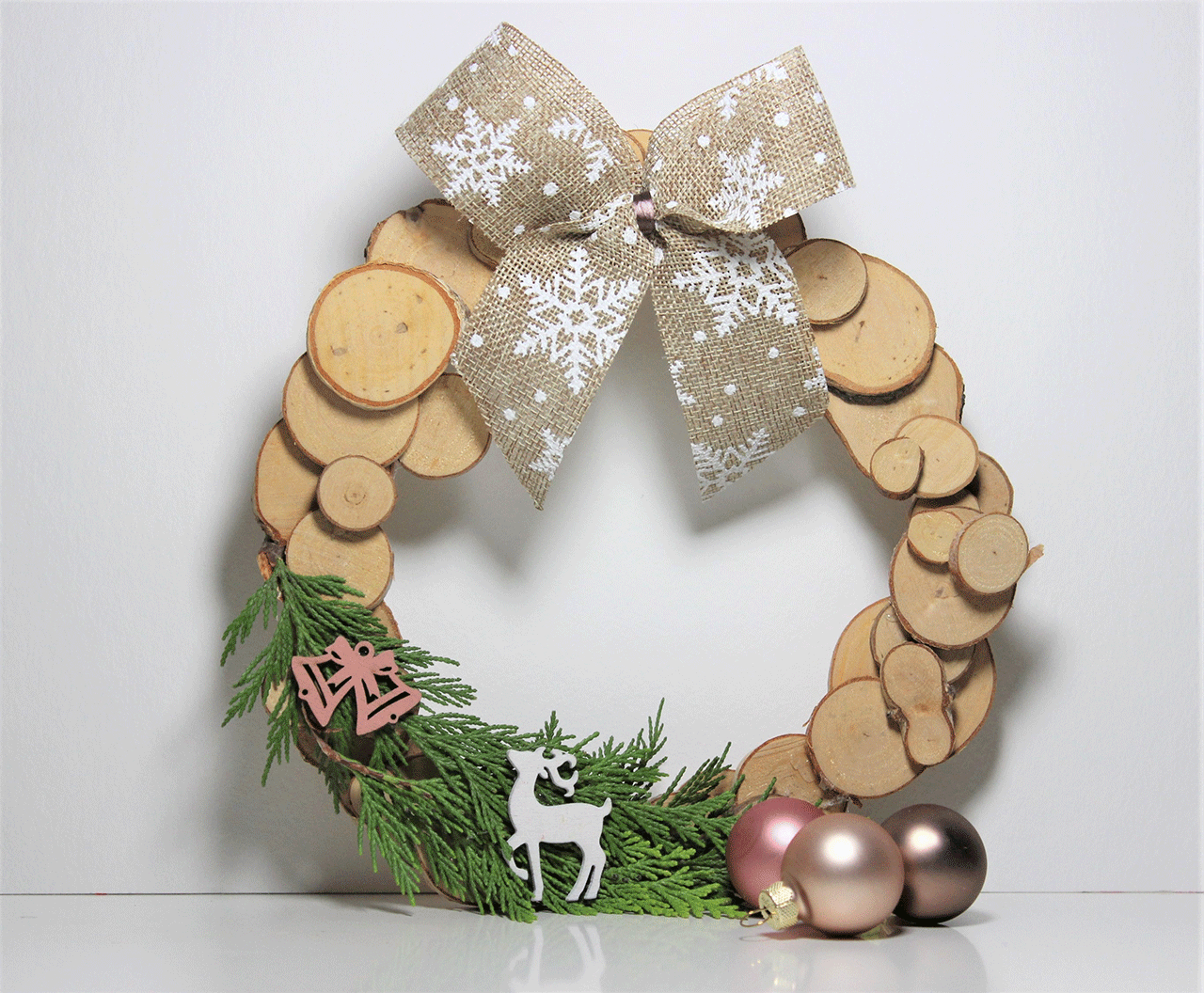 Selbst gemachter winterlicher Türkranz aus Holzscheiben.