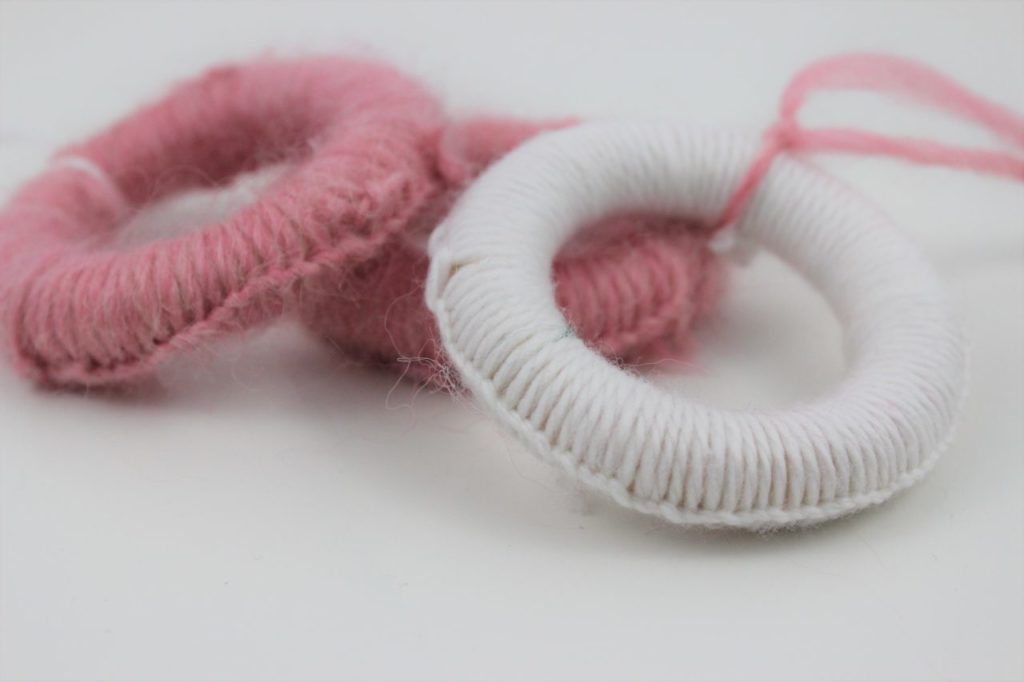 Selbst gemachter Tannenbaumschmuck Vorhang Ringe umwickelt mit Wolle als Aufhänger für den Weihnachtsbaum.