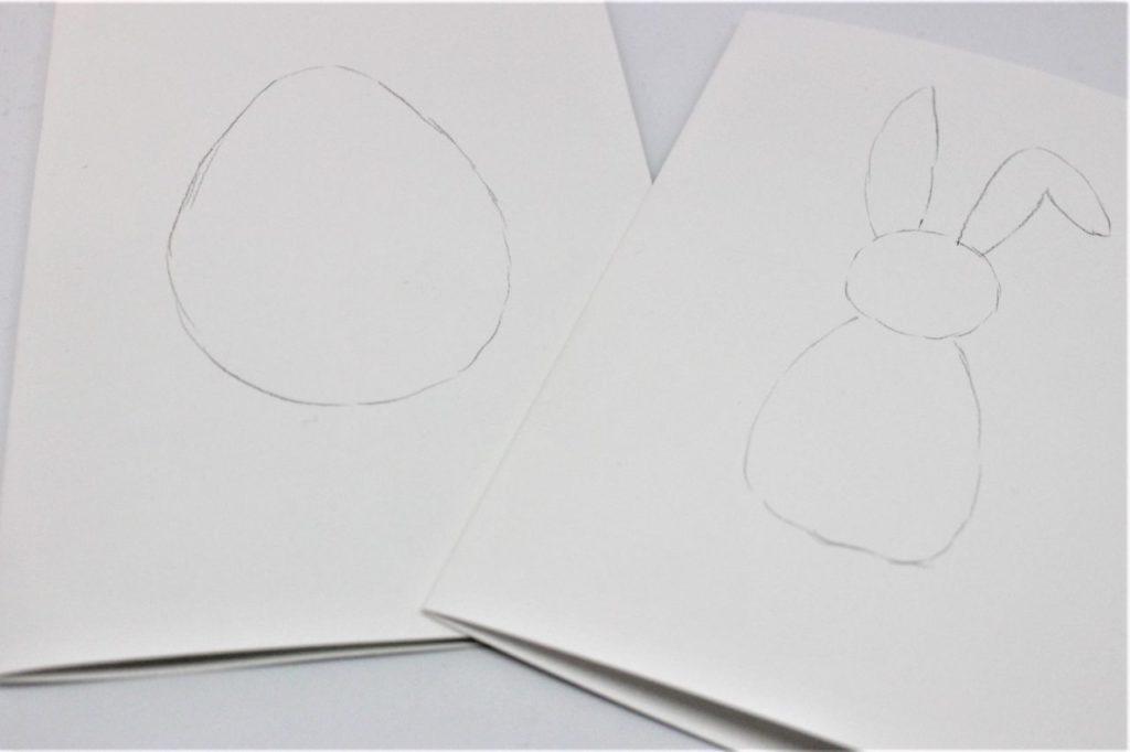 Auf die selbst gebastelte Karte werden Ostermotive mit einem Bleistift gezeichnet.