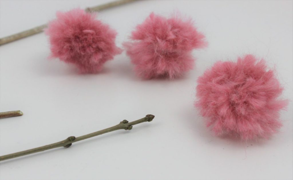 Die Pompoms werden an die Äste geklebt und fertig ist die DIY Frühlings Deko.