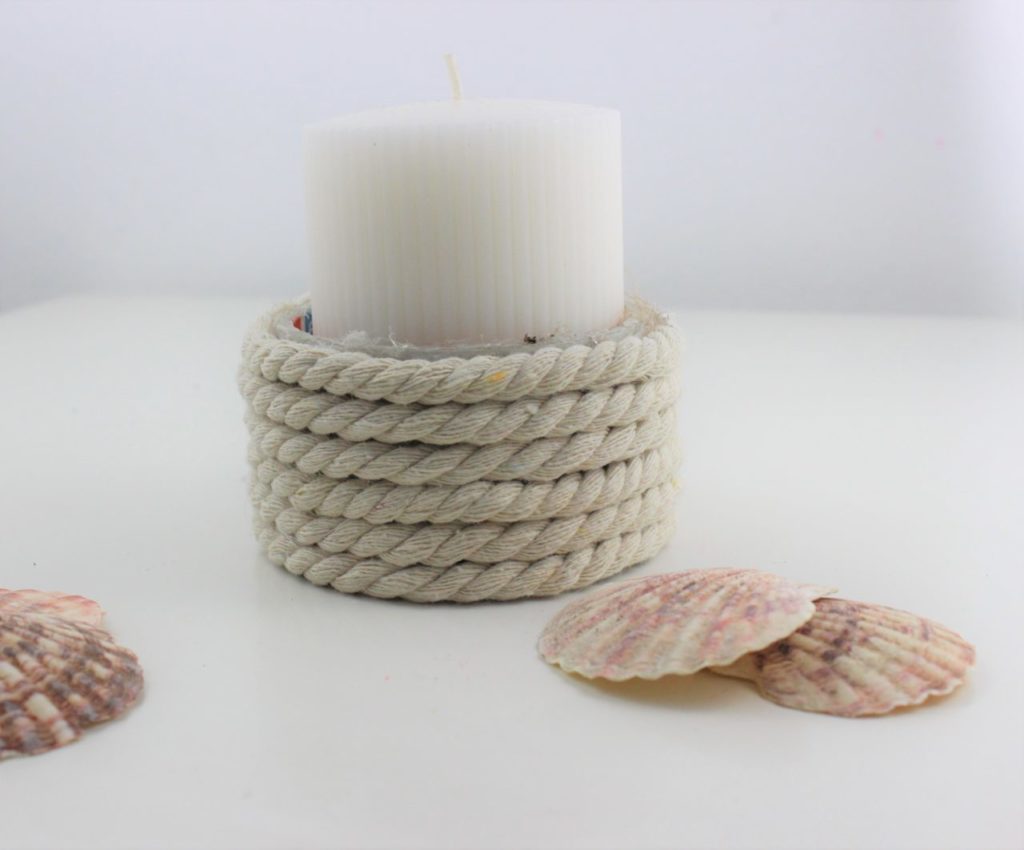 Der upcycling Kerzenhalter wird mit Muscheln verschönert.