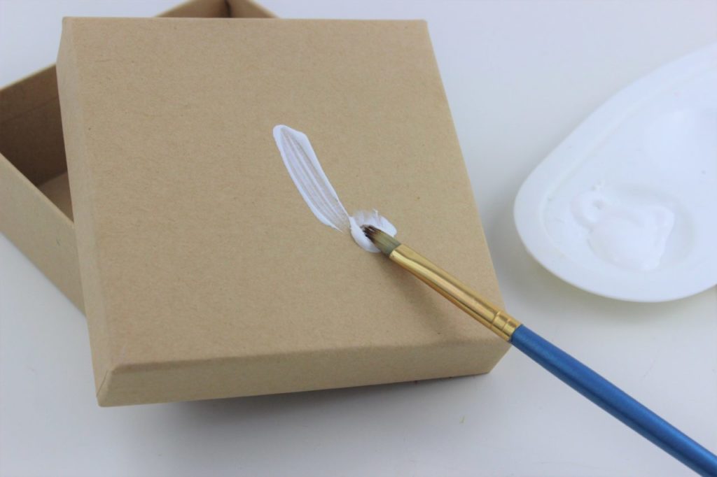 Dei selbst gestaltete Geschenkschachtel wird zu Beginn weiß grundiert.