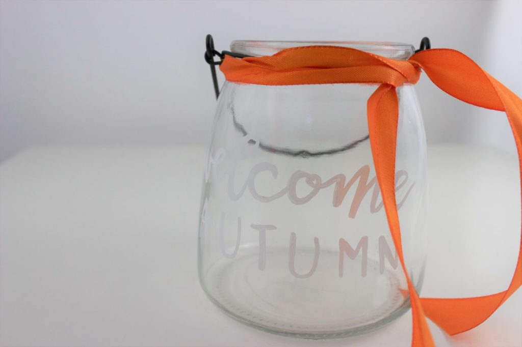 Das herbstliche Windlicht wird mit Naturmaterialien gefüllt und mit einer Schleife dekoriert.