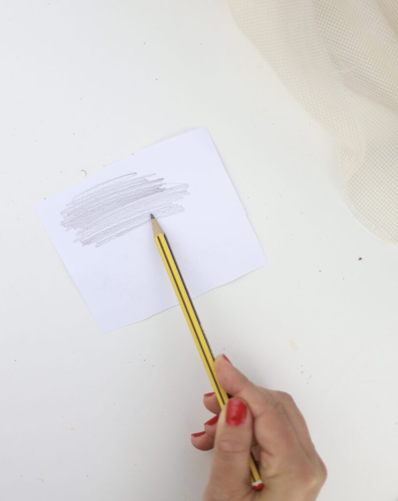 Mit einem Bleistift wird das Bild schraffiert um es auf die Spardose leicht zu übertragen.